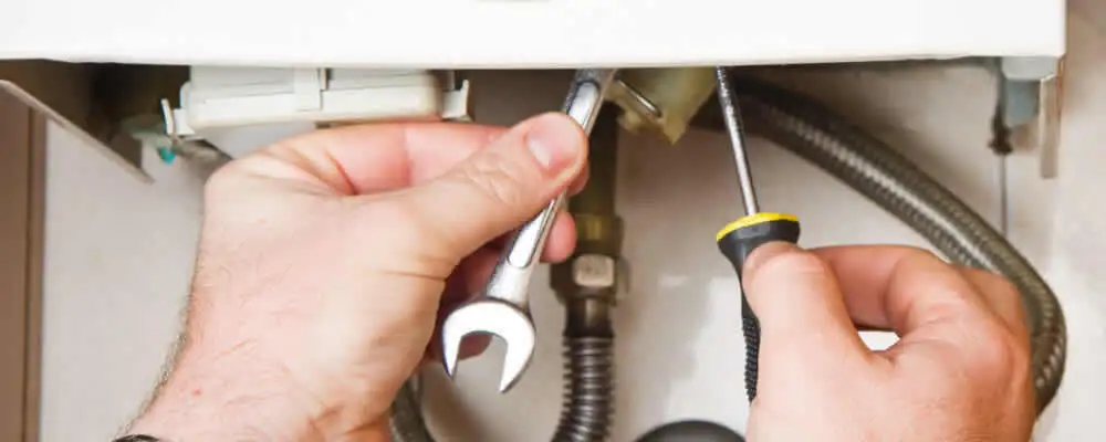 Boiler repair technician tightening pipe fittings and connections in Memphis, TN