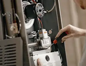 Furnace repair technician inspecting internal components and wiring in Memphis, TN