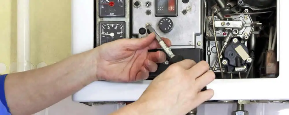 Heating repair technician adjusting boiler controls and components in Memphis, TN