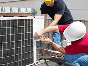 HVAC technicians repairing an outdoor AC unit on a rooftop in Memphis, TN