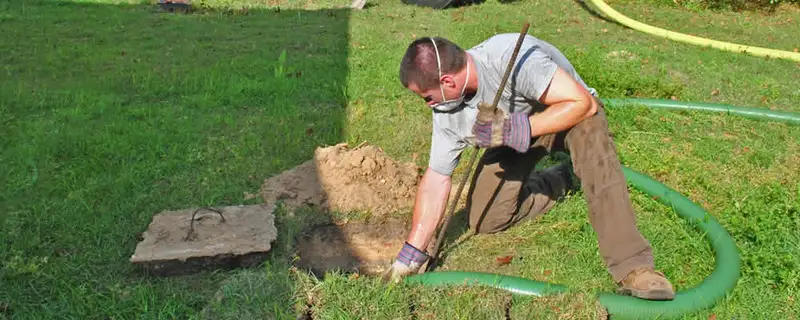 Septic pumping technician servicing a residential septic tank in Memphis, TN