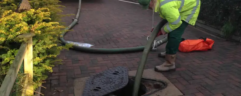 Septic tank cleaning technician servicing a septic tank with a vacuum hose in Memphis, TN