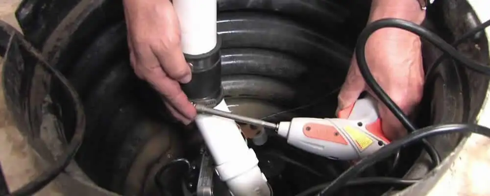 Sump pump installation technician connecting PVC discharge piping in Memphis, TN